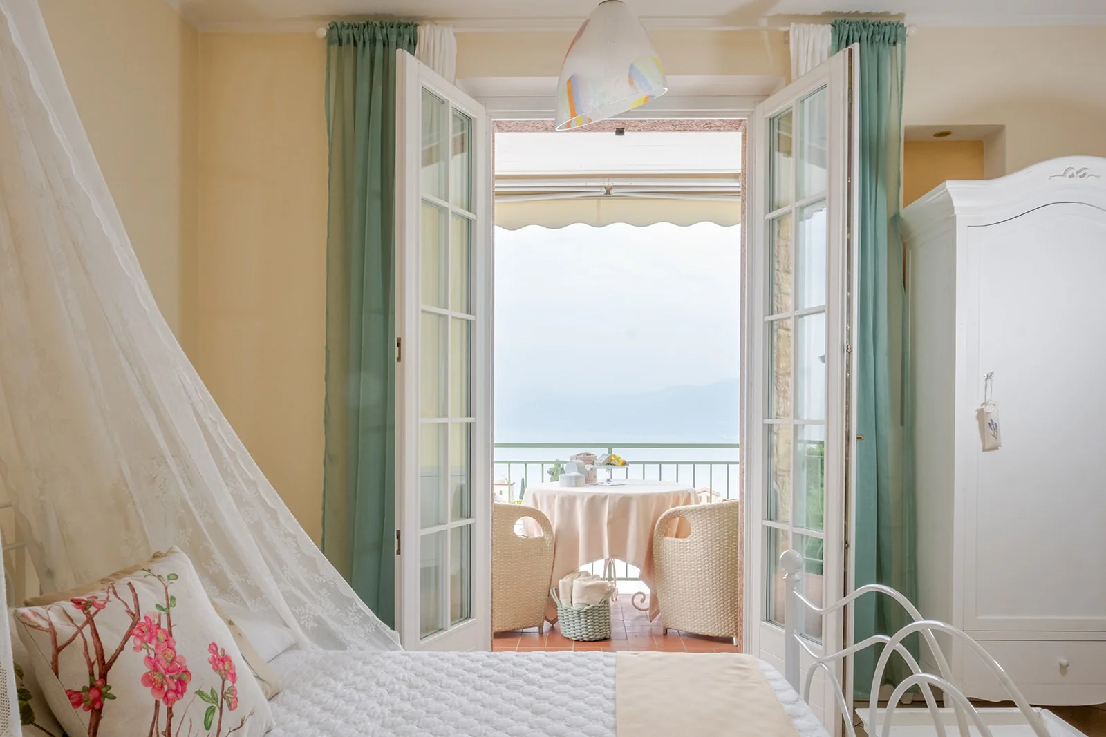 Gemme Suite — camera con vista sul Lago di Garda Gemme Suite: camera con porta-finestra aperta sulla terrazza con vista Lago di Garda