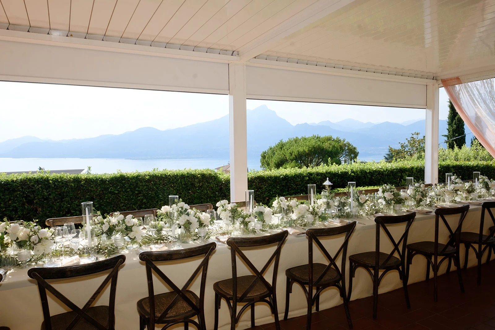 Banchetto matrimoniale nella veranda con vista giardino Banchetto matrimoniale con tavoli apparecchiati nella veranda affacciata sul giardino e gli ulivi